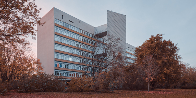 Außenansicht eines modernen Wohnhauses, umgeben von Herbstbäumen im Hansaviertel, Berlin.