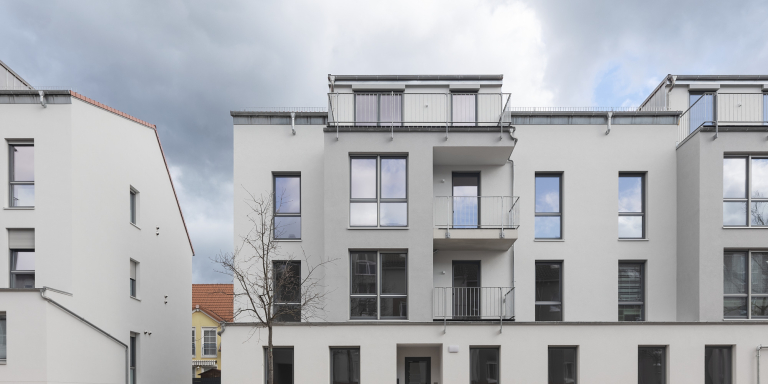 Reihe moderner Stadthäuser in der Nähe von Hoppegarten, Berlin, mit klaren architektonischen Linien und große Fenster.