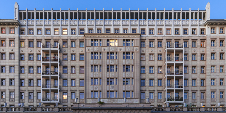 Front view of a classic multi-story office building with symmetrical windows on Karl-Marx-Allee, Berlin.