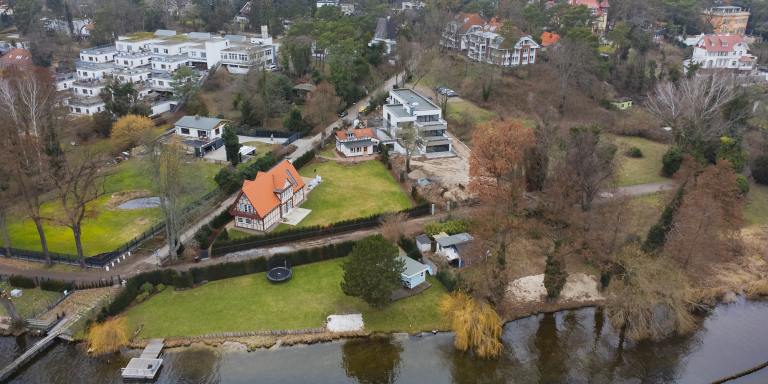 Aerial view of a scenic real estate property with winding pathways and a small river in Kladow, Berlin.