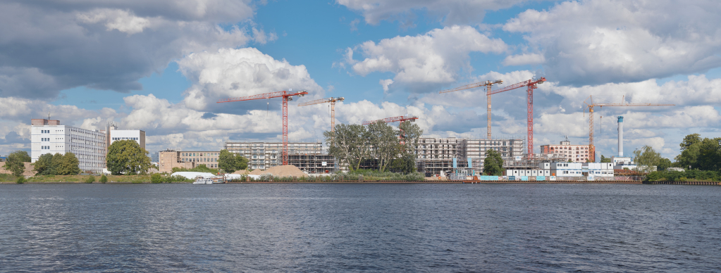 Panoramablick über die Dahme auf eine Baustelle für einen großen Wohnkomplex in Köpenick, Berlin.