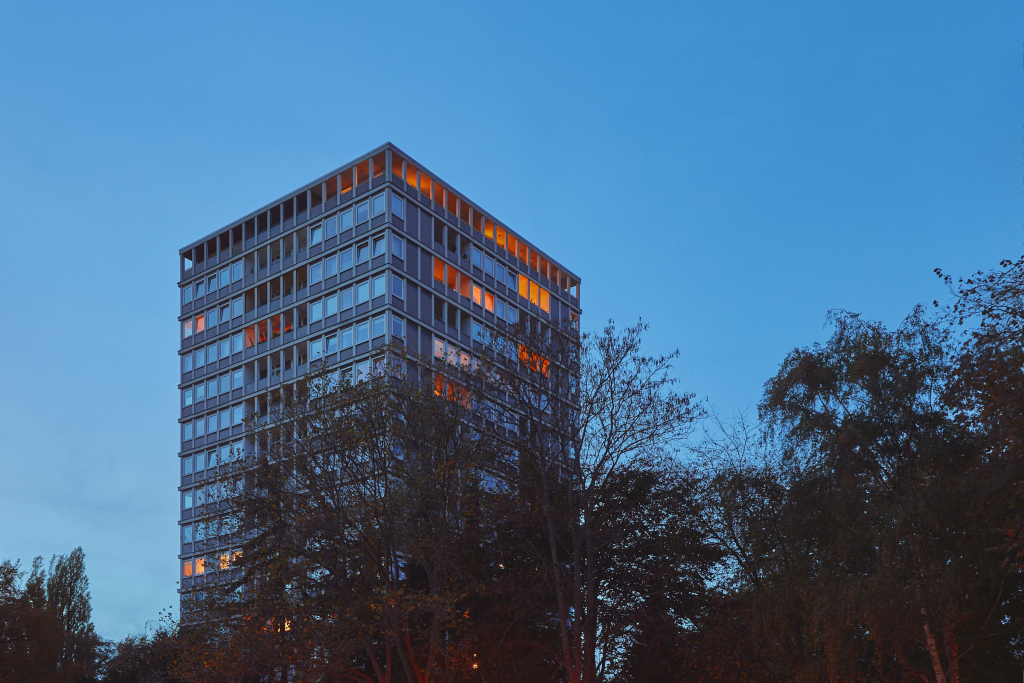 A high-rise apartment complex rises above the trees near S Bellevue in Berlin.