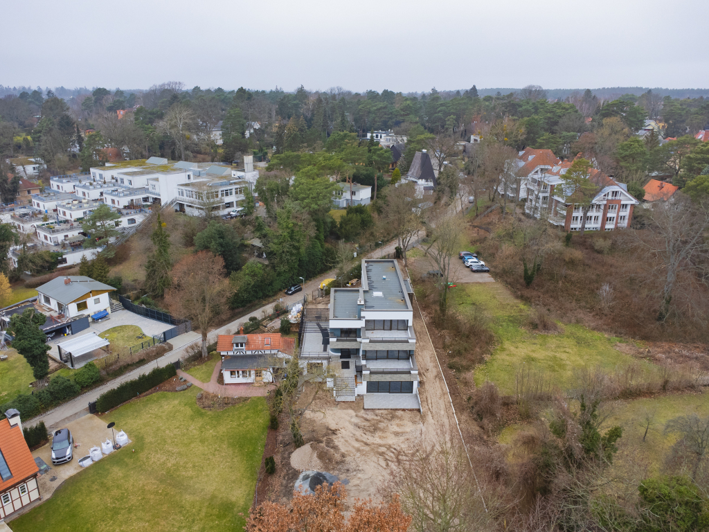 Aerial anterior view of an under construction property and its surroundings by a river near Kladow, Berlin.