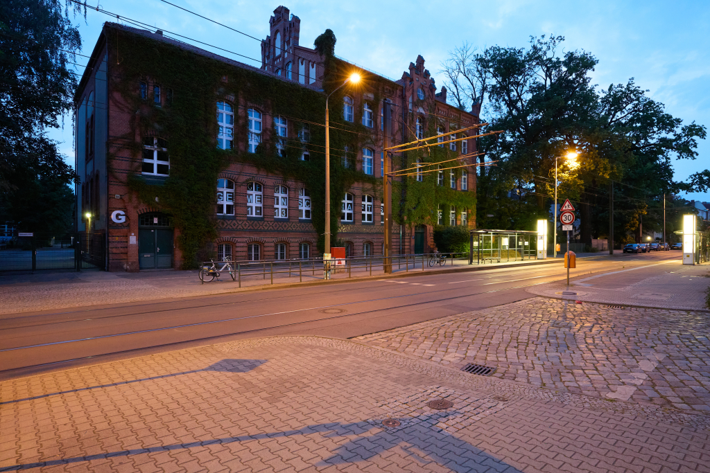 Blick über die Straße auf eine Gemeinschaftsschule am frühen Abend in Grünau, Berlin. Testbild mit hohem Rauschen mit einer Canon 5DS R bei ISO 6400.