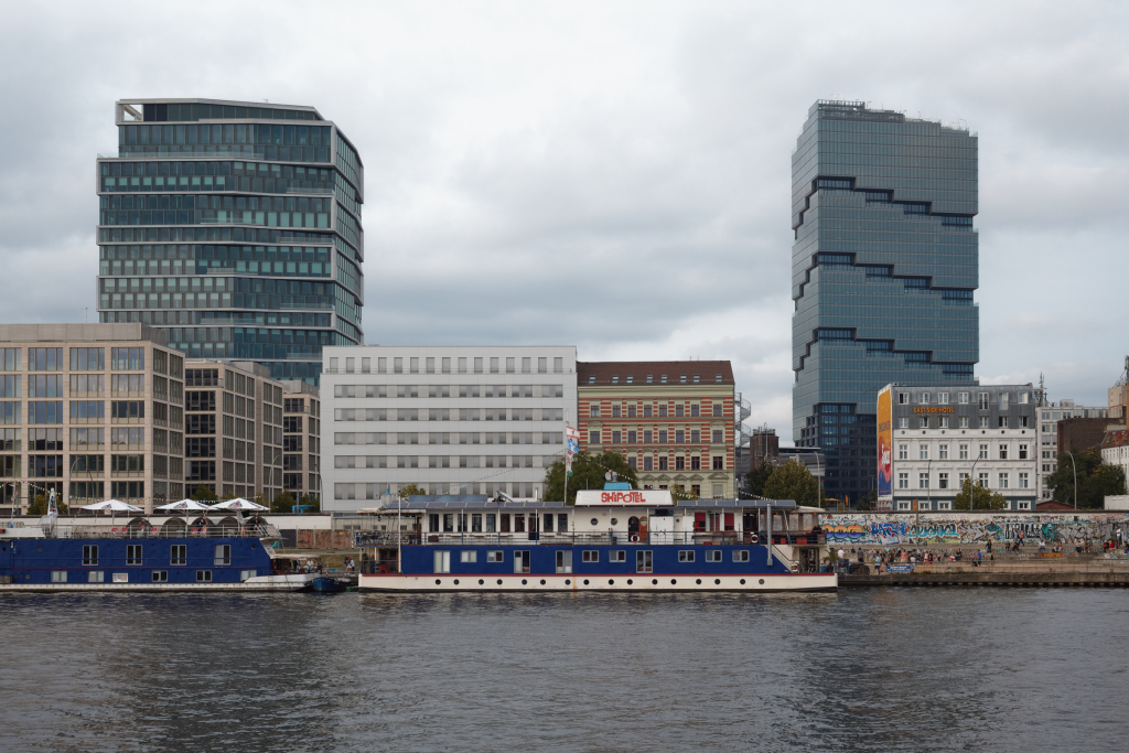 View across the Spree of the East Side Gallery, Berlin with the Amazon Tower and Zalando headquarters in the background.