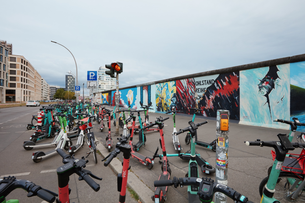 Numerous scooters are parked at the beginning of the East Side Gallery near Ostbahnhof, Berlin.