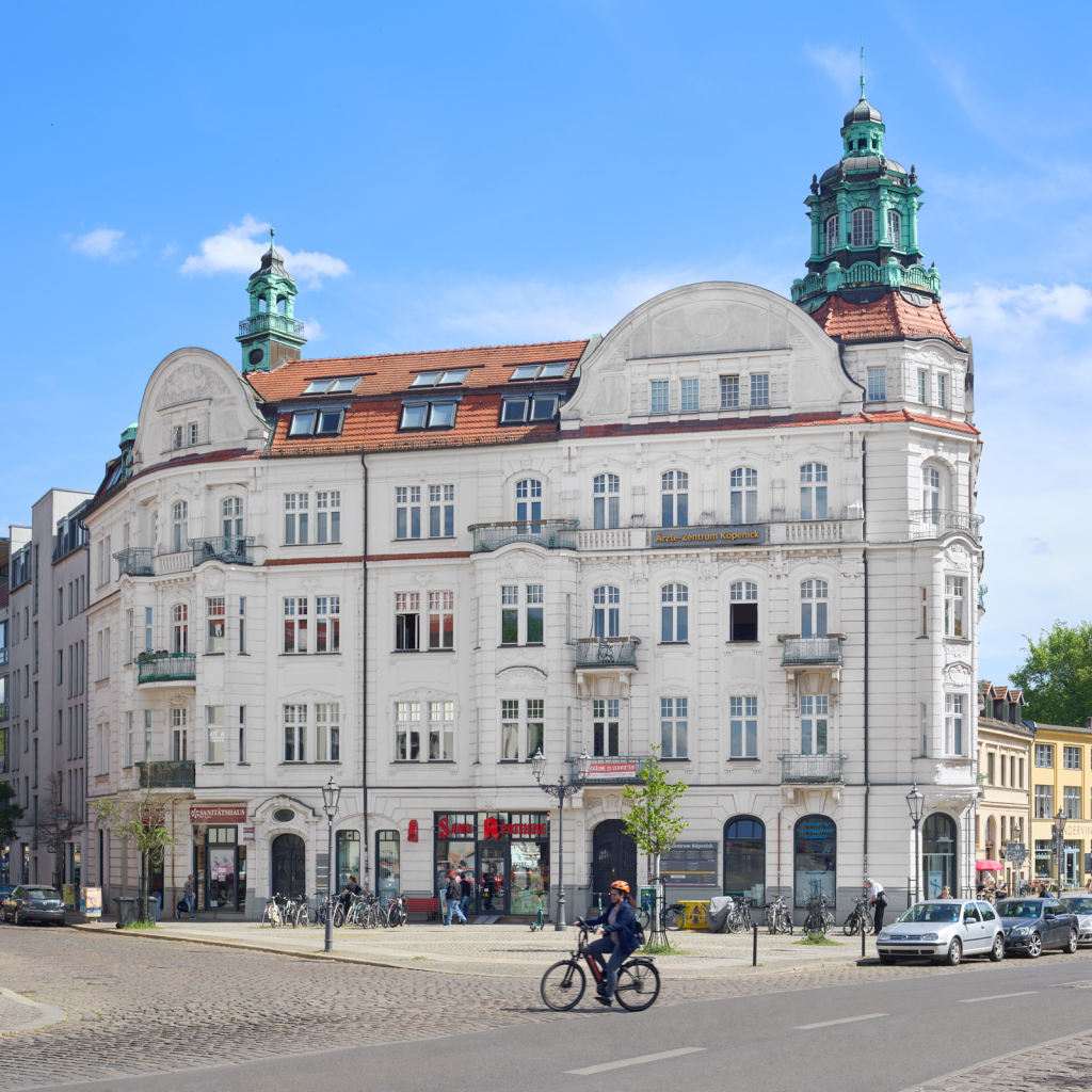 A cyclist in front of a historical building on the northern part of the Köpenickinsel in Berlin.