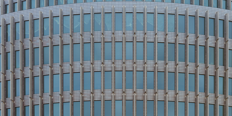 Nahaufnahme eines modernen Bürogebäudes am Kurfürstendamm in Berlin mit sich wiederholenden vertikalen Fenstermustern.