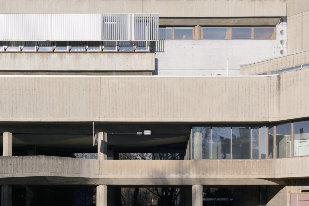 Detailansicht des Instituts für Hygiene und Umweltmedizin in Berlin, die die geschichteten Betonelemente und die geometrische Struktur zeigt.