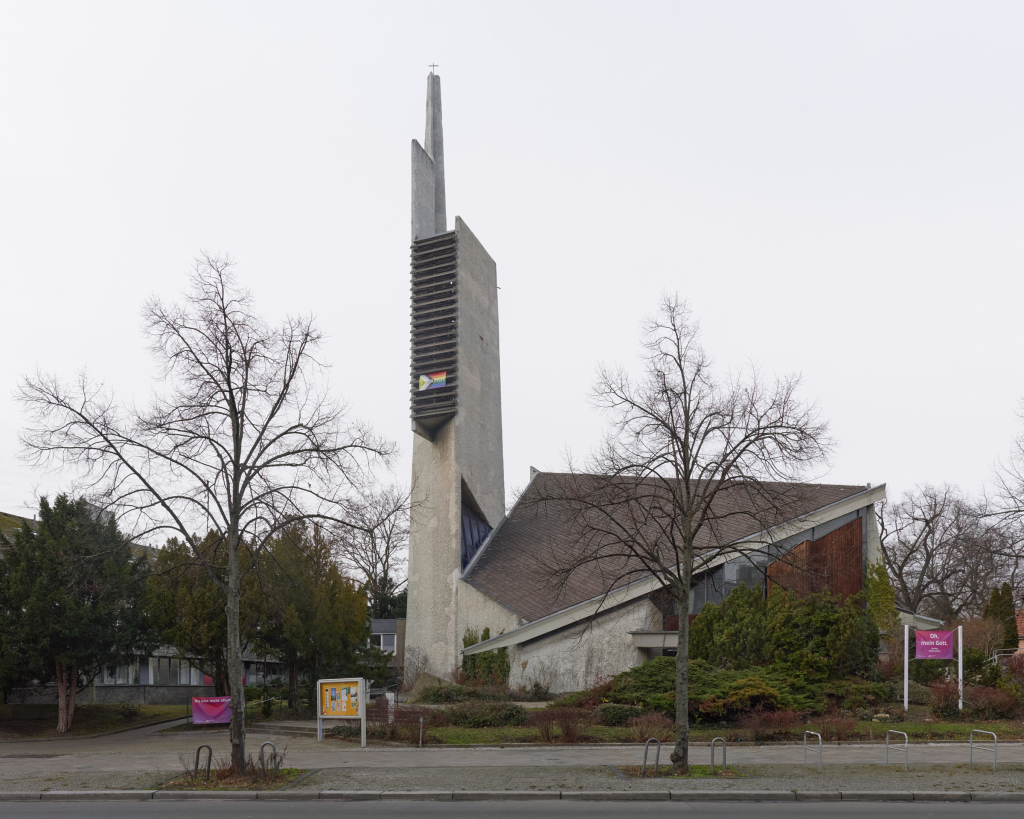 Straßenansicht der Paul-Gerhardt-Kirche in Schöneberg, Berlin, mit brutalistischem Design mit rohen Betonoberflächen, geometrischen Formen und minimaler Ornamentik.