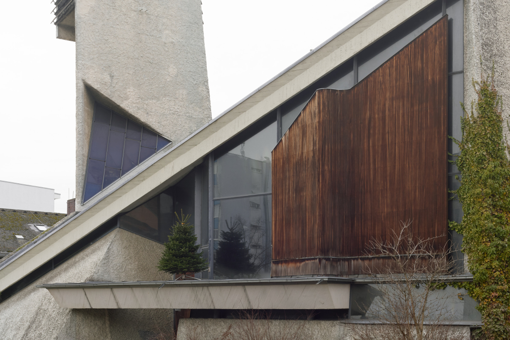 Detailaufnahme der Paul-Gerhardt-Kirche mit Holzelementen und dem dreieckigen Kirchturm.