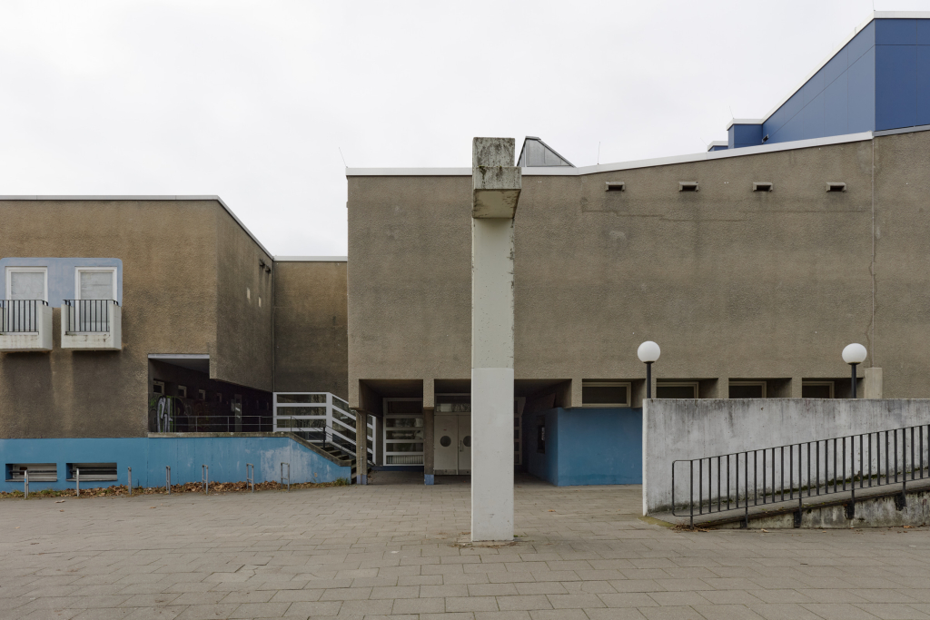 Seitenansicht der Gedenkkirche Plötzensee in Berlin, die rohe Betonoberflächen und kühne, kantige Formen zeigt.