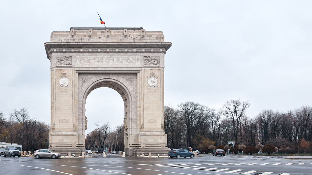 The Triumphal Arch (Arcul de Triumf) in Bucharest on a rainy day, commemorating Romanian WWI soldiers.