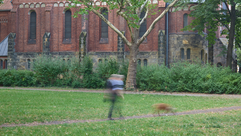 Man walking his dog near the Friedenskirche in Grünau, Berlin.