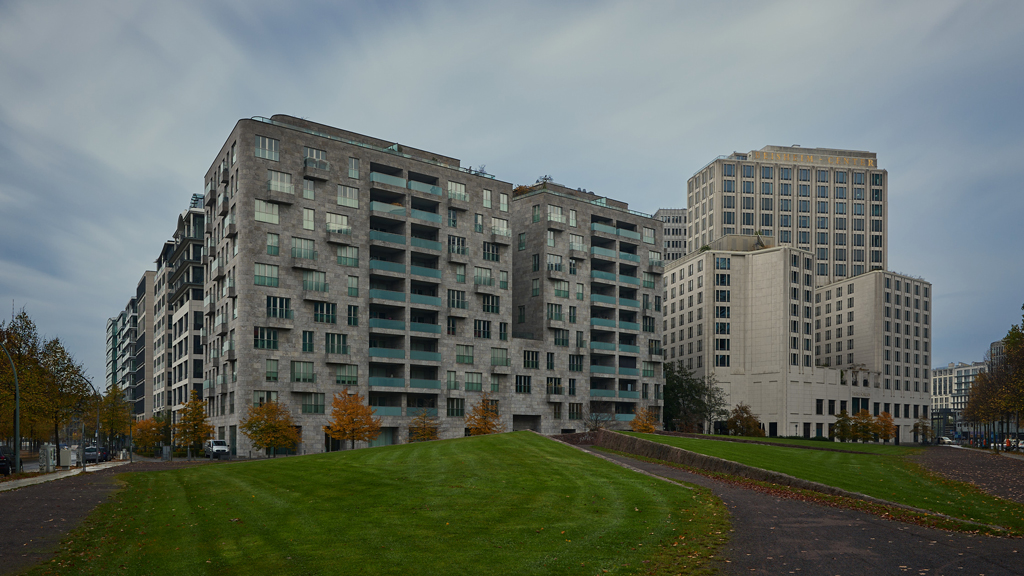 Long exposure of brutalist office buildings alongside the Ritz-Carlton Berlin under midday light.