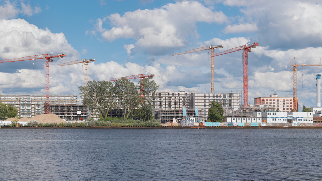 Wide-angle panorama capturing apartment complex development along the Dahme River in Köpenick, Berlin.