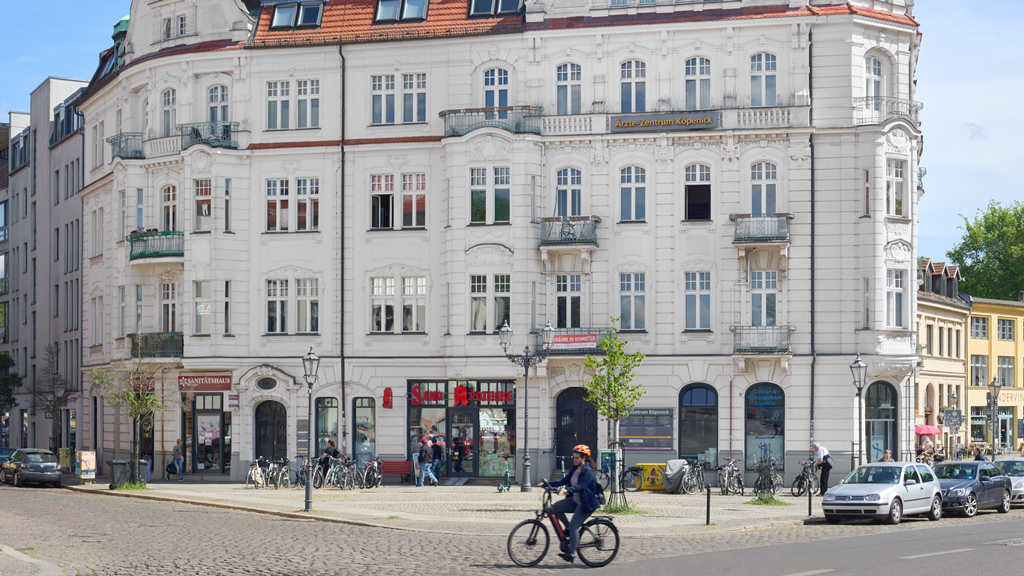Scene of a cyclist in front of a historical structure on the northern Köpenickinsel in Berlin.