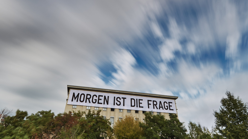 Long exposure of fast-moving clouds above Berghain nightclub in Berlin featuring the installation Tomorrow is the question by Rirkrit Tiravanija.